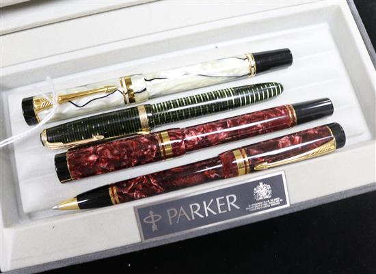 A Parker Duofold Black and Pearl fountain pen, a similar Red Marble pen and ballpoint set and a small Emerald Pearl pen